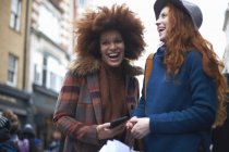 Две молодые женщины смеются на улице — стоковое фото