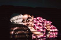 Девушка отдыхает на диване и держит смартфон — стоковое фото