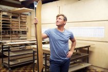 Mann in Werkstatt inspiziert Skiausrüstung — Stockfoto