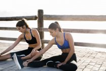 Two young women training on waterfront — Stock Photo