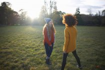Dos mujeres jóvenes de pie en un entorno rural - foto de stock