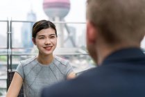 Young businesswoman and man meeting at sidewalk cafe in Shanghai, China — Stock Photo
