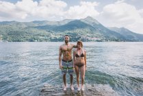Портрет пари в купальнику стоїть на краю озера Комо, Ломбардія, Італія. — стокове фото
