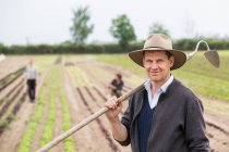 Portrait of farmer in field with hoe — Stock Photo