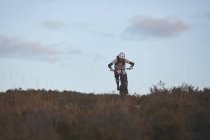 Masculino mountain biker equitação através de charneca — Fotografia de Stock