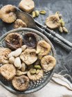 Draufsicht auf getrocknete Feigen und Nüsse in antikem Teller — Stockfoto