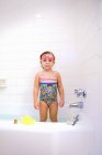 Retrato de niña con gafas de natación de pie en el baño - foto de stock