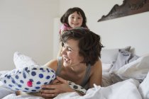 Madre e figlia giocare in camera da letto in camera da letto luce — Foto stock