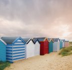 Рядок барвистий пляж хатин і грозових хмар, Southwold, Саффолк, Англія — стокове фото