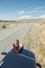 Женщина сидит на машине и смотрит на карту — стоковое фото
