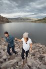 Couple walking on rocks beside Dillon Reservoir, elevated view, Silverthorne, Colorado, USA — Stock Photo