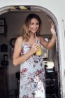 Portrait of young woman with fruit juice in airstream doorway — Stock Photo