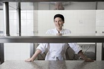 Porträt des Chefs in der Großküche, der lächelnd in die Kamera blickt — Stockfoto