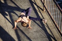 Jovem mulher em ambiente urbano praticando ioga — Fotografia de Stock