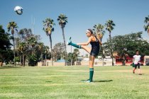 Школярка штовхає футбольний м'яч на шкільне спортивне поле — стокове фото