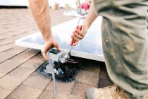 Workman installing solar panels on roof of house, mid section, close-up — Stock Photo