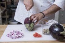 Vista ritagliata dello chef affettare melanzane — Foto stock