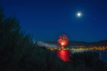 Canada Day celebration over Okanagan Lake, full moon in sky, Penticton, British Columbia, Canada — Stock Photo