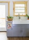 White washbasin on gray bedside table in bright kitchen — Stock Photo