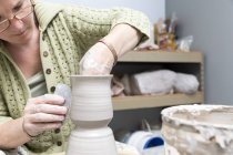Жінка працює з керамікою в студії художника — стокове фото