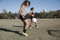 Mulheres do campo de futebol jogando futebol — Fotografia de Stock