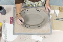 Pintura femenina en bandeja de cerámica - foto de stock