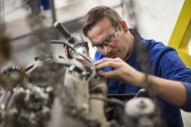Mechaniker inspiziert Autoteil in Werkstatt — Stockfoto