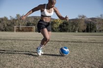 Donne sul campo da calcio a giocare a calcio — Foto stock
