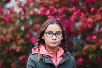 Ritratto di ragazza con trecce e occhiali che guarda la macchina fotografica — Foto stock