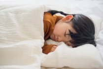 Petite fille dormir dans le lit — Photo de stock
