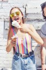 Jeunes femmes mangeant cône de crème glacée fondante — Photo de stock