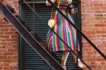 Jeune femme sur escalier de bâtiment industriel avec appareil photo numérique — Photo de stock