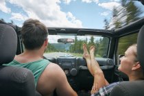 Jovem mulher com os pés para cima dirigindo em viagem de carro com namorado, Breckenridge, Colorado, EUA — Fotografia de Stock