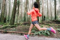 Vista lateral da mulher correndo na floresta, Vancouver, Canadá — Fotografia de Stock
