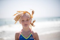 Girl wearing seaweed hair accessory on beach, Destin, Florida — Stock Photo