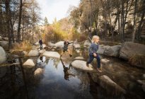 Crianças brincando em rochas no rio, Lake Arrowhead, Califórnia, EUA — Fotografia de Stock