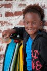 Portrait de jeune garçon en plein air tenant skateboard — Photo de stock