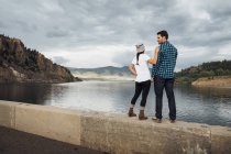Пара стоящая на стене рядом с водохранилищем Диллон, вид сзади, Силверторн, Колорадо, США — стоковое фото