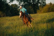 Adolescente menino equitação cavalo no campo — Fotografia de Stock
