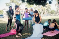 Colegialas preparándose para la práctica de yoga en el campo deportivo escolar - foto de stock