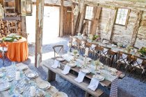 Place settings with table decorations in barn — Stock Photo