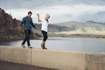 Пара, идущая вдоль стены рядом с водохранилищем Диллон, Силверторн, Колорадо, США — стоковое фото