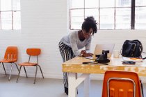 African-american Woman in industrial office building using laptop — Stock Photo