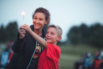 Mother and son holding sparkler smiling — Stock Photo