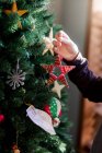 Primo piano del bambino che mette le decorazioni di Natale — Foto stock