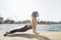 Young woman outdoors, in yoga position, Long Beach, California, USA — Stock Photo