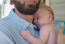 Homem com menino adormecido no ombro — Fotografia de Stock