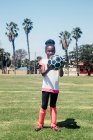 Portrait of schoolgirl soccer player holding soccer ball on school sports field — Stock Photo