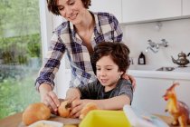 Mother and son preparing food in kitchen — Stock Photo