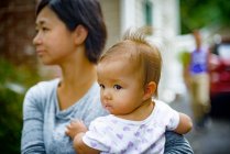 Mitte erwachsene Frau trägt kleine Tochter im Arm — Stockfoto